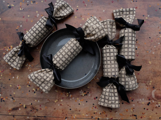 four Ludo print reusable luxury Christmas crackers surrounding  a table setting